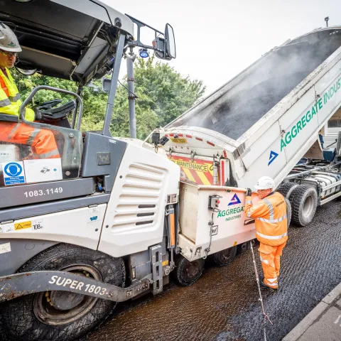 Two of the Aggregate Industries Surfacing Solutions team resurfacing a road with machinery